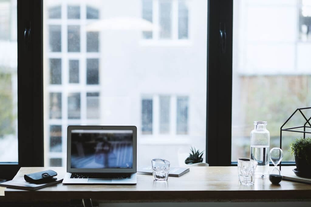 A clean desk with a laptop and open notebook, representing planning.