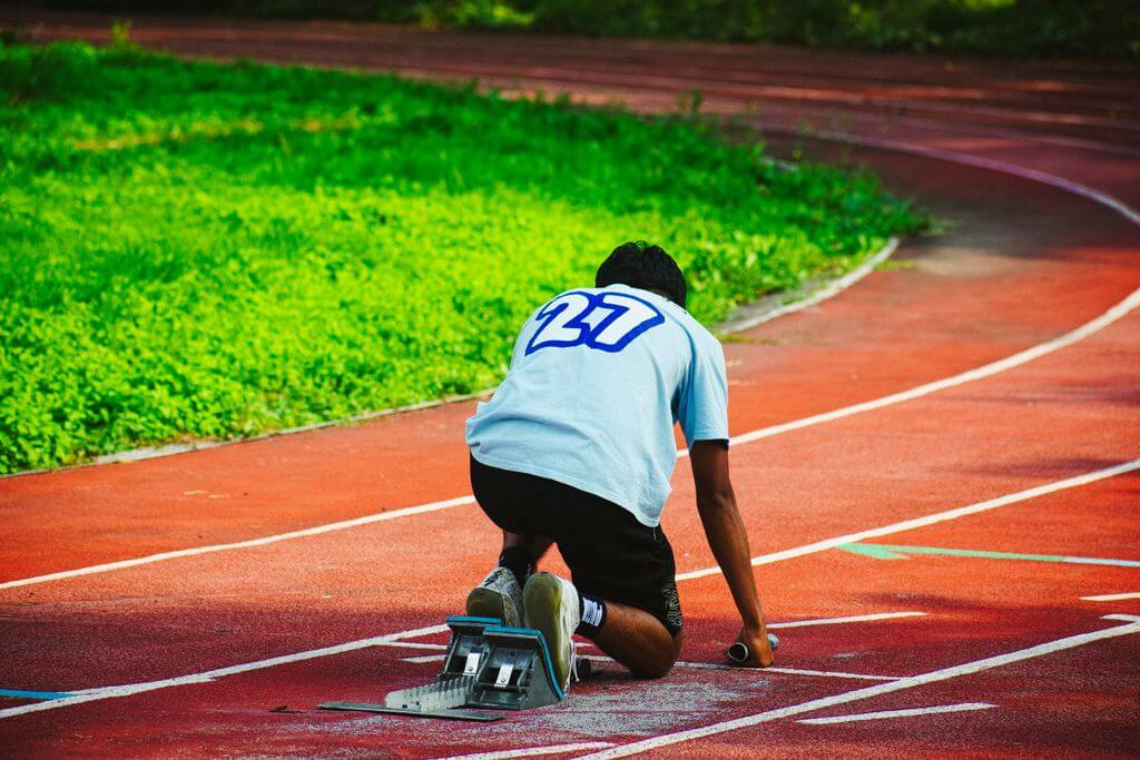 a person preparing to sprint on the running track